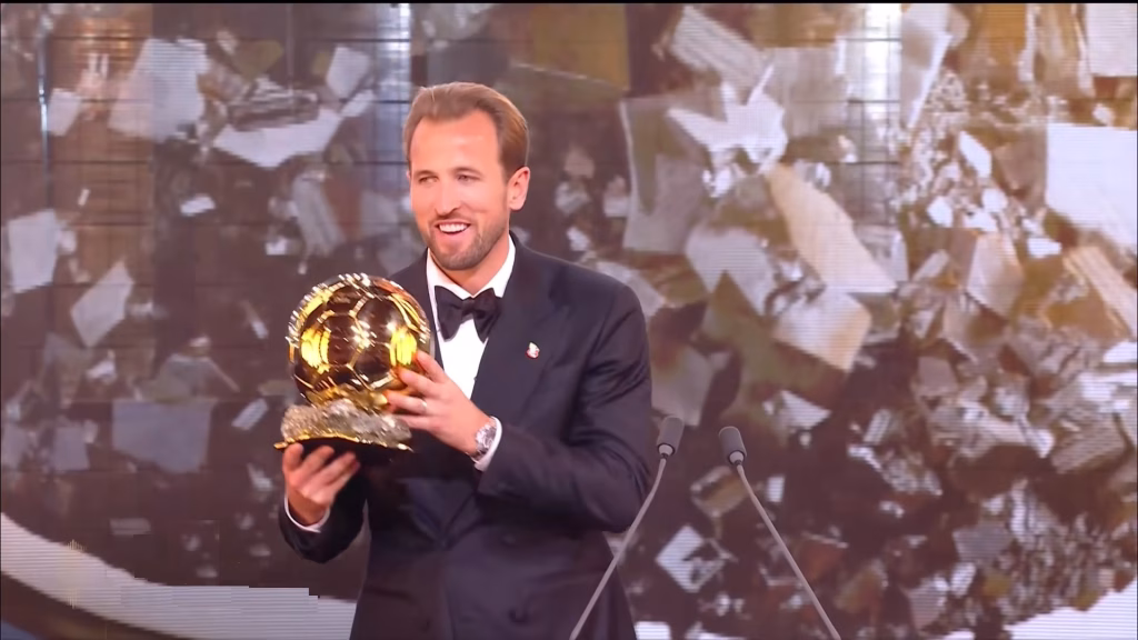 Harry Kane tout sourire soulevant son premier trophée du Ballon d'Or 2026 à Londres